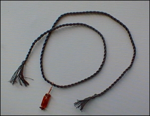 Greeny blue floss, copper wire and red glass beads.